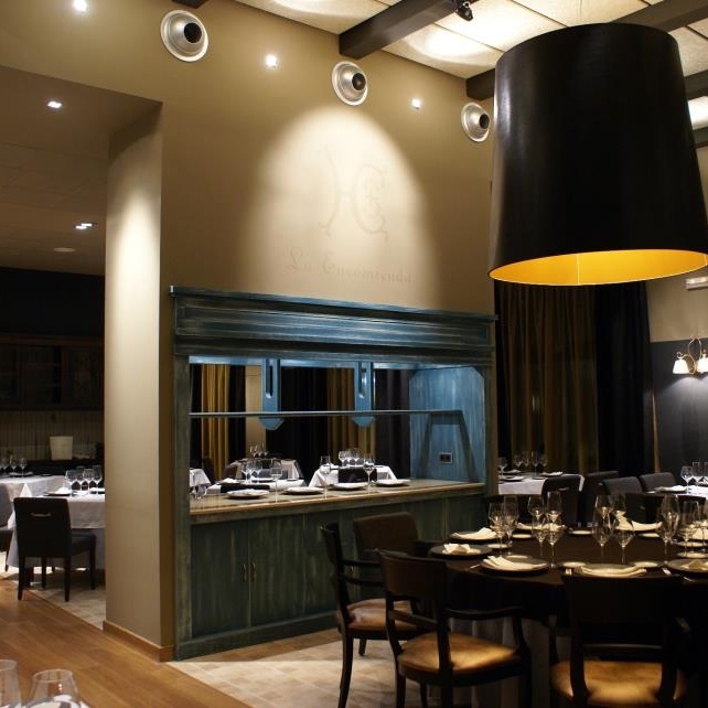 Interior de un restaurante con mesas preparadas.